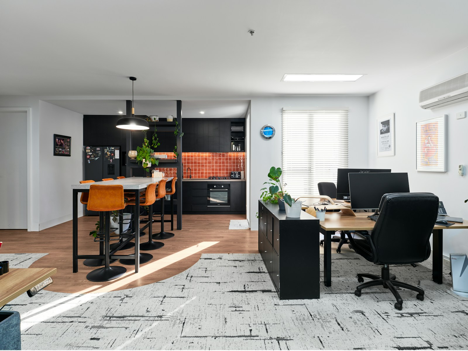 Modern office space with kitchen and work areas.